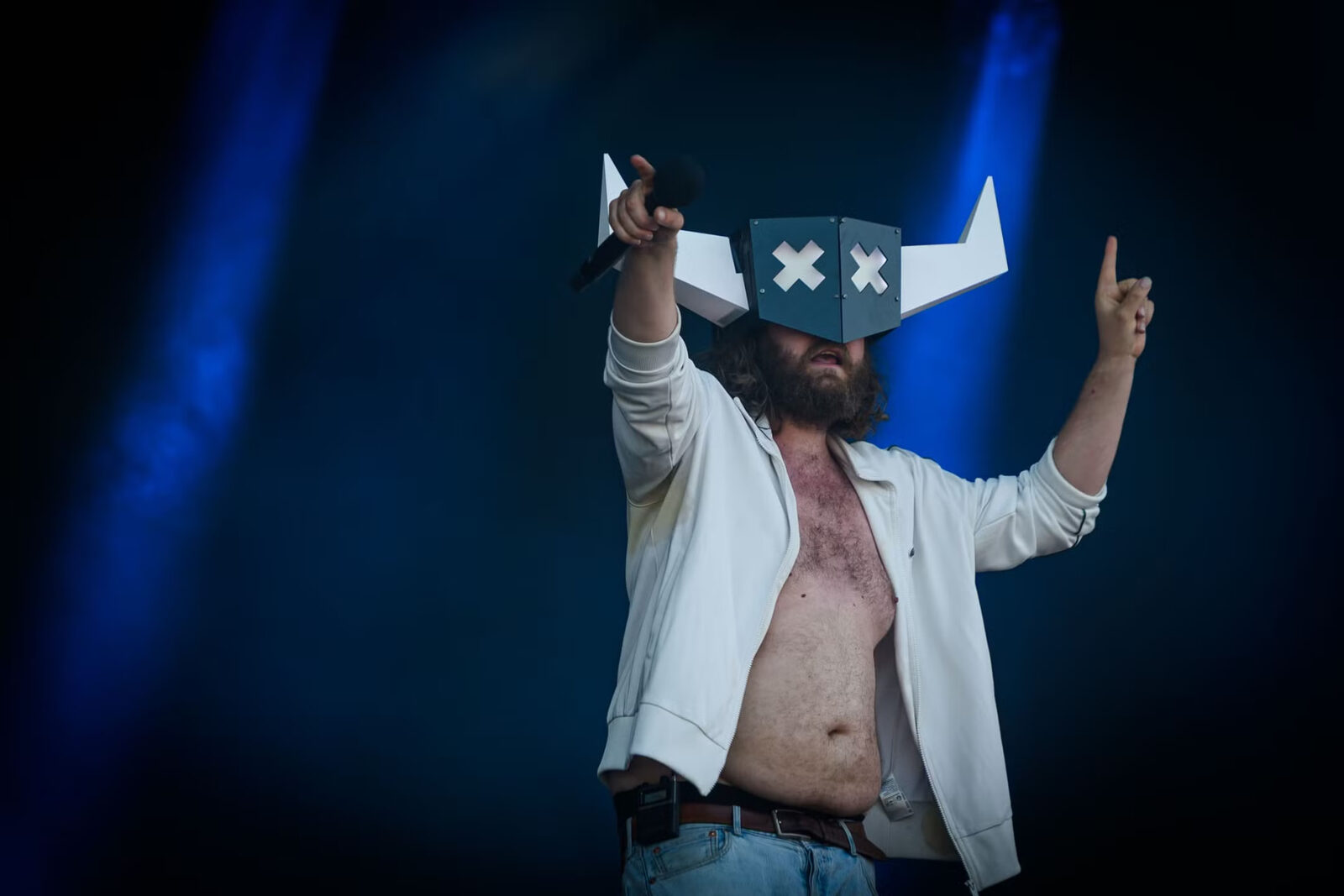 Artist med hornmaske peker mot publikum