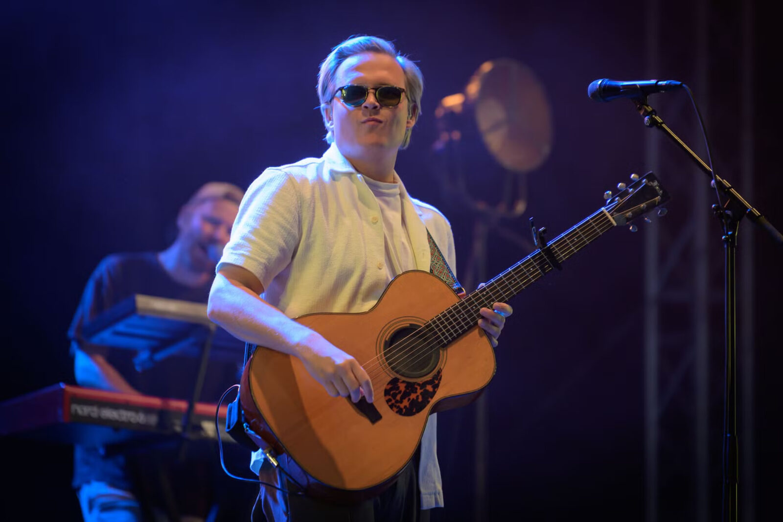 Gitarist med solbriller i blått scenelys