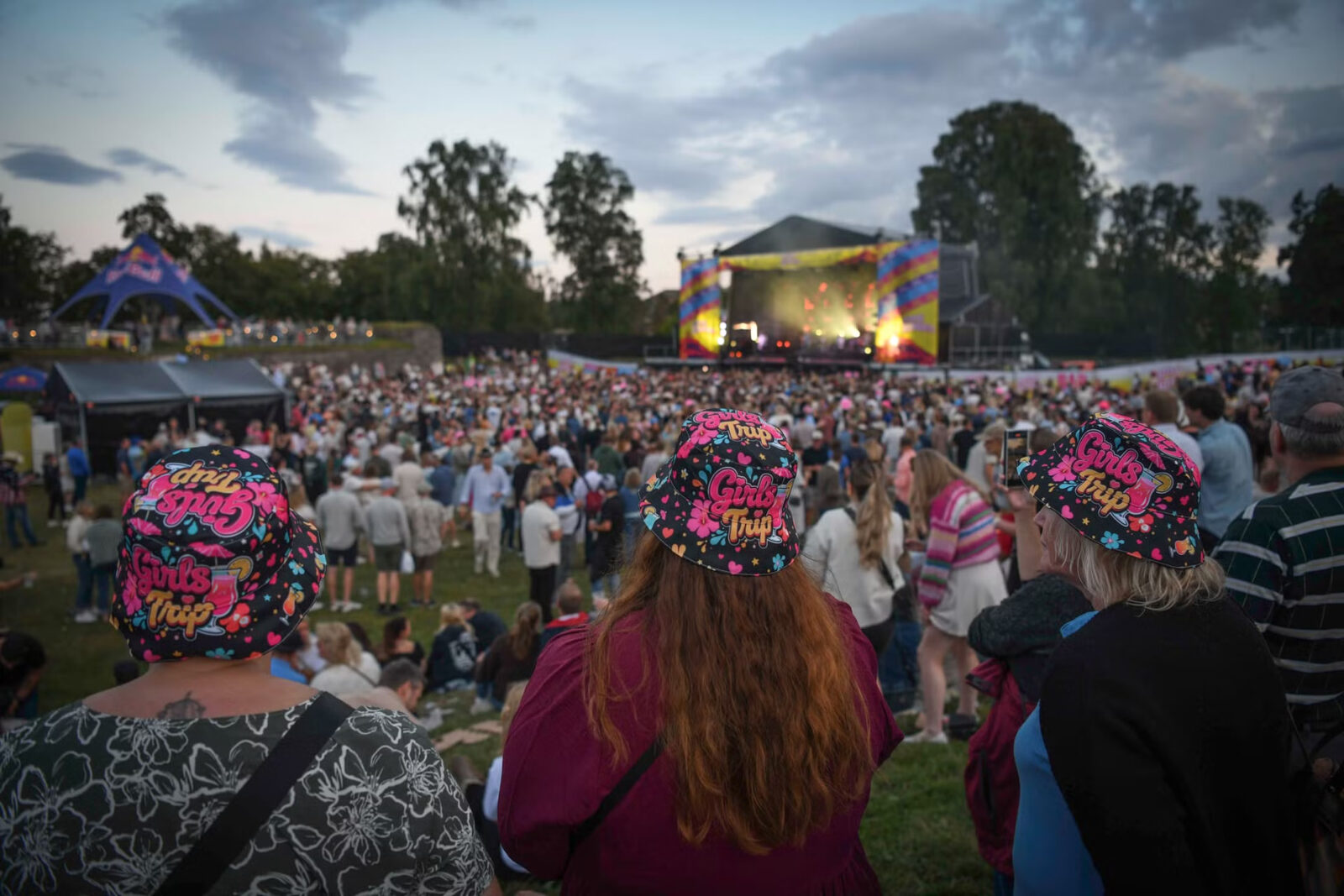 Publikum med bøttehatter foran scenen i skumringen